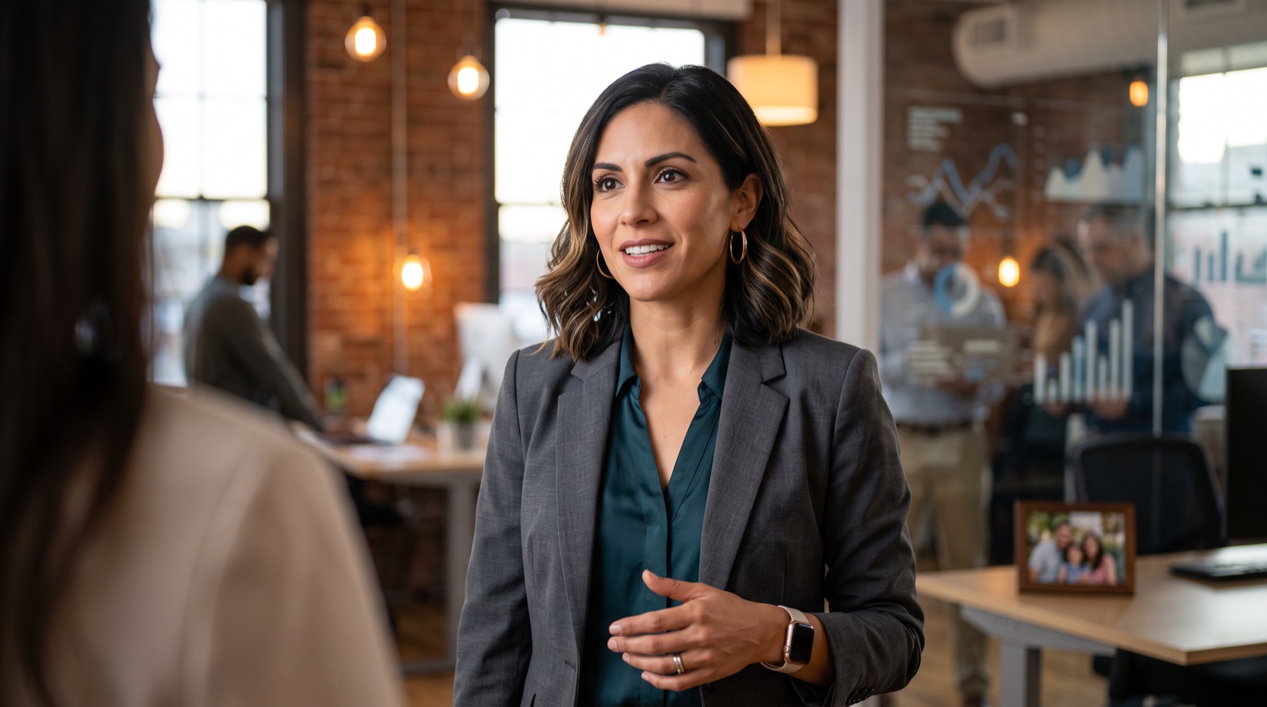 A woman in her mid-40s leading a conversation in a warm brick-walled office